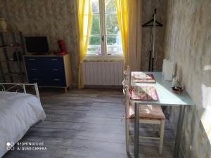 une chambre avec une table, un lit et une fenêtre dans l'établissement La case, à Arros-de-Nay