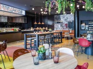 um restaurante com mesas e cadeiras e um bar em Novotel Barcelona Cornellà em Cornellà de Llobregat