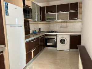 a kitchen with brown cabinets and a washer and dryer at Bucharest City Center Apartment in Bucharest