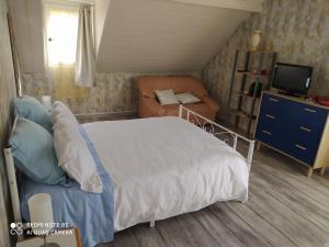 une chambre avec un lit, un canapé et une télévision dans l'établissement La case, à Arros-de-Nay