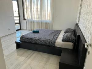 a large bed in a room with a large window at Bucharest City Center Apartment in Bucharest