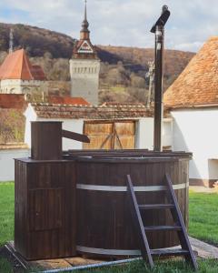un soporte de madera con un micrófono y un edificio en Castle View, en Saschiz