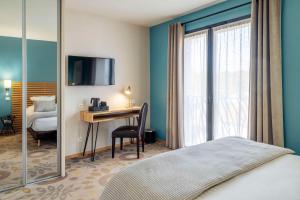 1 dormitorio con 1 cama y escritorio con ordenador en Best Western Plus Hotel De La Regate-Erdre, en Nantes