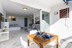 a dining room and living room with a table and chairs at Home2Book Bright Studio Ocean View Tabaiba in Tabaiba