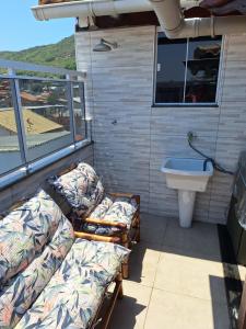 Habitación con 2 camas y lavabo en el balcón. en Residencial Flat do Pontal, en Arraial do Cabo