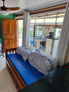 a bed in a room with a large window at Residencial Flat do Pontal in Arraial do Cabo