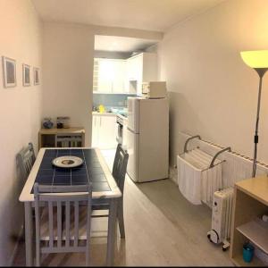a small kitchen with a table and a refrigerator at Lovely 12th floor 2 bed flat in the heart ofLondon in London