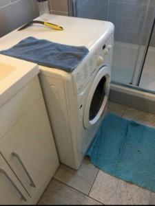 a washing machine in a bathroom next to a shower at Lovely 12th floor 2 bed flat in the heart ofLondon in London