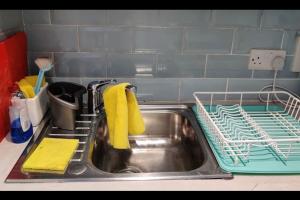 a kitchen sink with a dish drying rack and towels at Lovely 12th floor 2 bed flat in the heart ofLondon in London