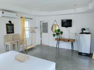 a room with a refrigerator and a table and a tv at Thongtalay Bed & Breakfast Koh Larn in Ko Larn