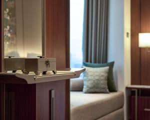 a bathroom with a mirror and a couch in a room at Grand Hyatt Jakarta in Jakarta