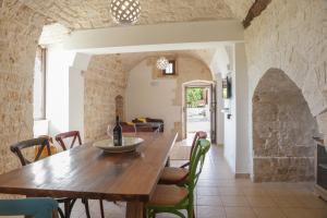 a dining room with a wooden table and chairs at Trulli Dimore - Saveni in Castellana Grotte
