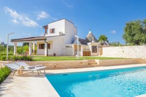 a villa with a swimming pool in front of a house at Trulli Dimore - Saveni in Castellana Grotte
