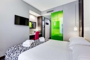 una camera con un letto bianco e una parete verde di Best Western Cinemusic Hotel a Roma