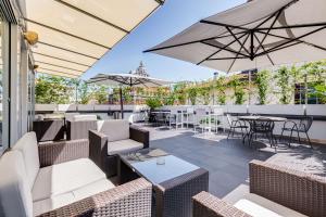een patio met stoelen, tafels en parasols bij Best Western Cinemusic Hotel in Rome