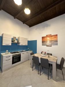 a kitchen with a table and chairs in a room at The Flower Garden in Castellammare di Stabia