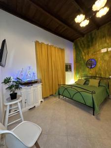 a bedroom with a green bed and a chair at The Flower Garden in Castellammare di Stabia