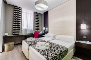 una camera d'albergo con due letti e un bagno di Best Western Cinemusic Hotel a Roma