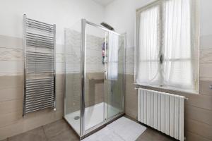 y baño con ducha de cristal y ventana. en La Casa di Ugo, en Loano