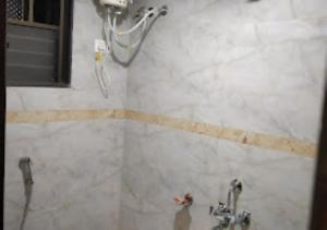 a shower in a bathroom with two faucets at Hotel New Delhi darbar family restaurant Jalgaon in Jālgaon