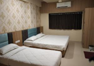 1 dormitorio con 2 camas y ventana. en Hotel New Delhi darbar family restaurant Jalgaon, en Jālgaon