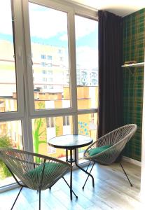 ヴィーンヌィツャにあるW&B на Коцюбинськогоの窓のある客室で、椅子2脚とテーブル1台が備わります。