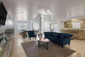 a living room with a blue couch and a table at Super 8 by Wyndham Harbison/Parkridge Hospital in Columbia