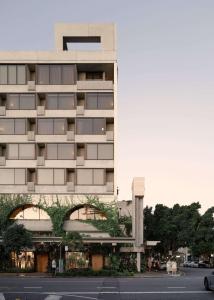 een hoog gebouw met een straat ervoor bij The Calile Hotel in Brisbane