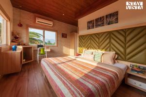 a bedroom with a bed and a desk and a window at Golden Sunsets by StayVista - Refreshing pool, serene lawn - your tranquil retreat in Alibaug