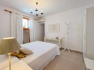 a white bedroom with a bed and a lamp at Finca Margarita Cas Concos in Caʼs Concos +41 photos