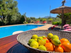 a basket of fruit sitting on a table next to a pool at Finca Margarita Cas Concos in Caʼs Concos