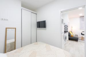 a white bedroom with a bed and a mirror at Market Martinez de la Riva II in Madrid