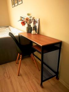 a desk with a chair and a table with flowers at Kalina Apartment Kazanlak in Kazanlŭk +23 photos