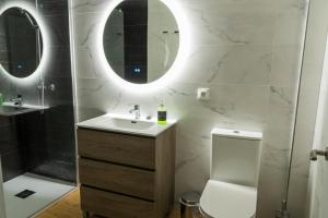 a bathroom with a sink and a toilet and a mirror at Rooms Luxury Madrid in Madrid