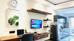 a home office with a desk and a tv on a wall at BluO Studio1 DLF CyberCity - Balcony, Gym TT, Lift in Gurgaon