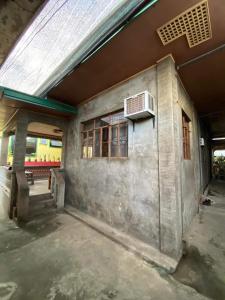 Perucho-Silang Guest House في مابيني: محطة قطار مع مبنى مع نافذة