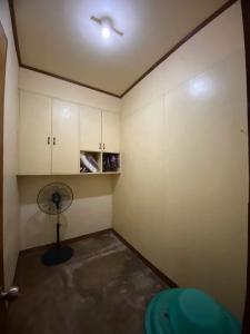 a room with a room with a fan and cabinets at Perucho-Silang Guest House in Mabini
