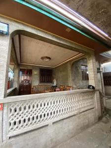 einen Balkon eines Gebäudes mit einem Tisch und Stühlen in der Unterkunft Perucho-Silang Guest House in Mabini
