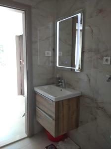 a bathroom with a sink and a mirror at Apartments and rooms Porto in Ražanj +48 photos
