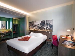 リヨンにあるGreet Hotel Lyon Confluenceの大きなベッドとデスクが備わるホテルルームです。