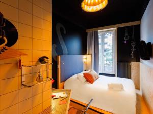 1 dormitorio con cama blanca y ventana en Greet Hotel Lyon Confluence, en Lyon