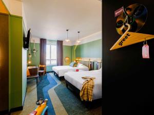 a hotel room with two beds and a desk and a room with a room at Greet Hotel Lyon Confluence in Lyon