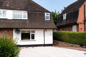 a white house with a black roof at Stunning 3-bed Home in Nottingham by Renzo, Driveway for 2 Cars, Perfect for Contractors! in Nottingham