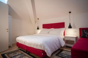 a bedroom with a red bed and a red couch at B&B PIEDICASTELLO in Trento