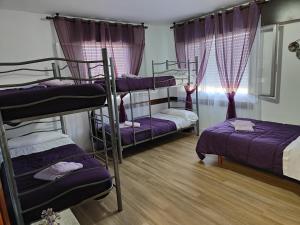 a room with three bunk beds and a window at Albergue Vintecatro in Caldas de Reis