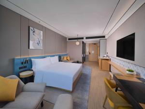 um quarto de hotel com uma cama e uma televisão em Hilton Garden Inn Xiamen Tong'An em Xiamen