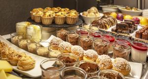 a buffet with many different types of pastries and desserts at Sure Hotel by Best Western Annecy in Annecy