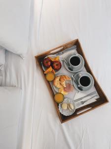 bandeja de alimentos para el desayuno en una cama en Argentino Hotel en Mendoza