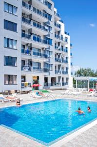 a swimming pool in front of a large apartment building at Ivtour Apartments in Yalta complex in Golden Sands