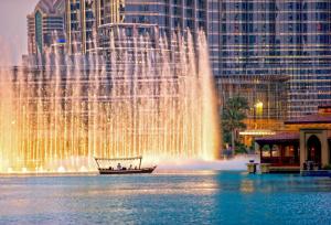 a boat in front of a fountain in a city at Rove Downtown in Dubai